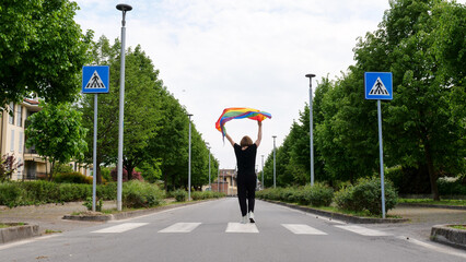 Bisexual, lesbian, female, transgender back walk with LGBTQIA flag, rainbow peace in pride mounts on the road on a day and celebrate Bisexuality Day or National Coming Out Day