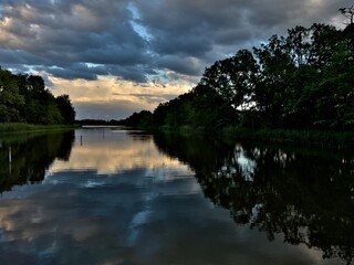 WIDOK NA JEZIORO. POPOŁUDNIE NAD JEZIOREM. CZAS WIOSNY. BURZOWA POGODA NAD JEZIOREM. STAWY MILICKIE, POLSKA. - obrazy, fototapety, plakaty