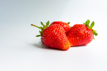 Red ripe juicy strawberries on a white gray background.