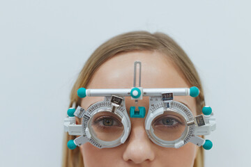 Eyesight Test. Close Up Portrait of Blonde Young Woman In Optometrist Trial Frame. Beautiful Girl...