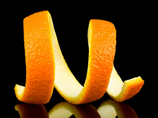 Spiral orange peel on a black background. Citrus zest. - obrazy, fototapety, plakaty