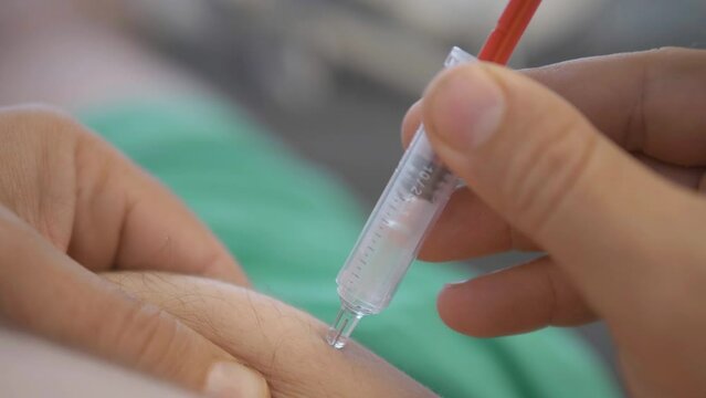 Detail of hands with syringe injecting vaccine in muscle, self administration