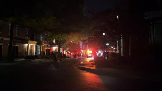 Fire truck emergency vehicles with flashing lights at night at a multifamily building