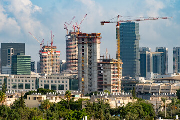Tel Aviv's skyline high rise construction with cranes and water heaters, Israel. A tall building in...