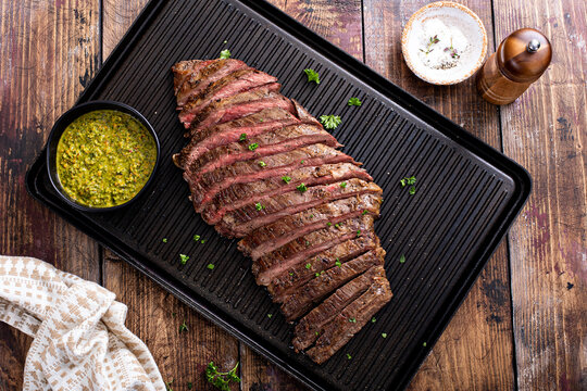 Grilled flank steak with chimichurri sauce on a grill pan