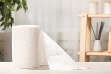 Roll of paper towels on white wooden table indoors. Space for text