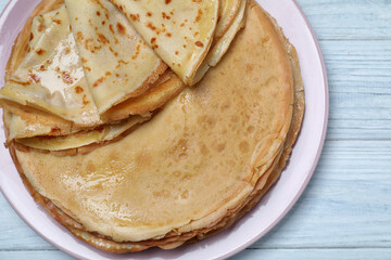 Delicious crepes on white wooden table, top view