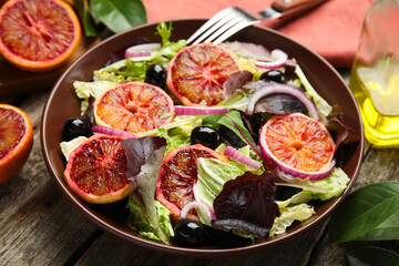 Bowl of delicious sicilian orange salad on wooden table, closeup