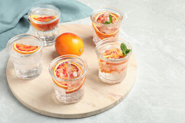 Delicious refreshing drink with sicilian orange on light grey marble table