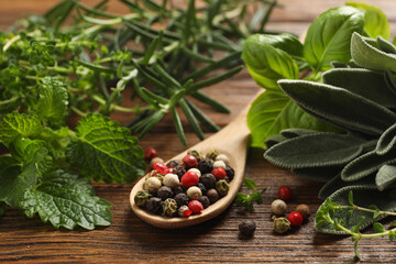 Different fresh herbs and spices on wooden table, closeup