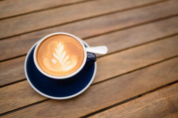 Cup of aromatic coffee on wooden table, above view. Space for text