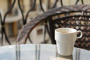 Ceramic cup of aromatic coffee on glass table outdoors, space for text. Good morning