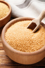 Brown sugar in bowls on wooden table, closeup