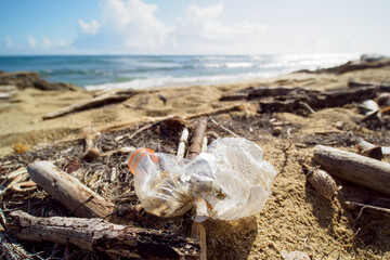 Old used plastic bottle washed up on shore in tropical beach. Dominican Republic.