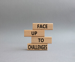 Face up to challenges symbol. Wooden blocks with words Face up to challenges. Beautiful grey background. Business and Face up to challenges concept. Copy space.