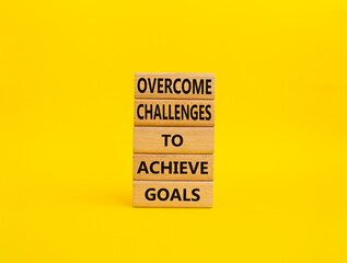 Challenges or goals symbol. Wooden blocks with words 'Overcome challenges to achieve goals'. Beautiful yellow background. Business and 'Overcome challenges to achieve goals' concept. Copy space.