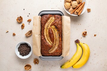 Traditional American homemade banana bread with chopped walnuts, chocolate chips and cinnamon in...