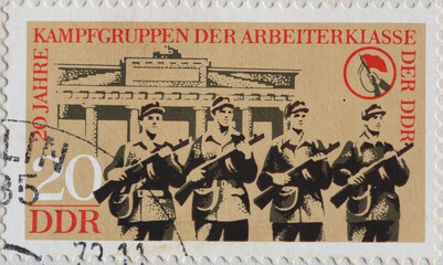 GERMANY, DDR - CIRCA 1973: a postage stamp from GERMANY, DDR, showing a member of the civilian combat groups with guns at the Brandenburg Gate, Berlin. Circa 1973