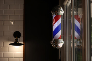 Barber pole spinning at night. International barbershop pole sign. A barber pole calling for people...