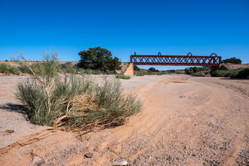 Old rusty railway bridge over dry river near Holoog Namibia