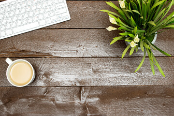 workspace : modern laptop with copy space, lilies flowers  and milk coffee cup on wooden table 