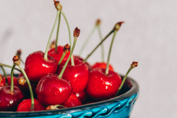 Bright juicy red cherry in the drops of water on the plate
