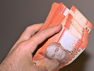 chilean pesos in a hand