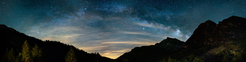 Milky Way arch and starry sky on the Alps. Panoramic view, astro photography, stargazing. Light...