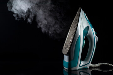 Steam iron on a dark background with a cloud of steam