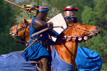 Knightly tournament on horseback. Two knights attack each other with spears at a gallop. One on one...