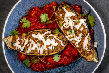 Baked aubergine or eggplant stuffed with minced pork and beef, carrots, peppers, tomatoes