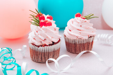 Sweets with pink cupcakes and air balloons on background, card with colorful dessert 