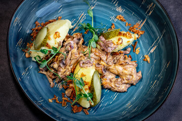 Beef stroganoff, goulash, with sauce and mushrooms, boiled potatoes.
National Russian dish of beef stroganoff with meat, boiled potatoes, mushrooms and fried onions.