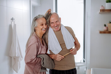 Senior couple in bathroom, brushing teeth and washing, morning routine concept.
