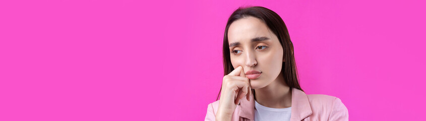 Fototapeta premium Portrait of beautiful young woman in pink jacket thinking isolated on red background