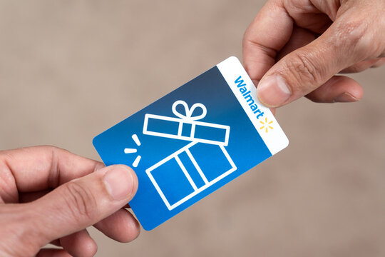 Hand giving out a Walmart gift card isolated