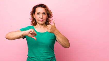 middle age hispanic woman feeling confused, clueless and unsure, weighting the good and bad in...