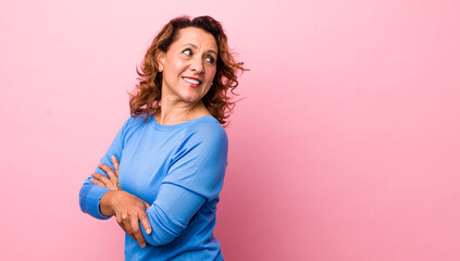 middle age hispanic woman smiling gleefully, feeling happy, satisfied and relaxed, with crossed...