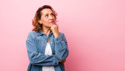 middle age hispanic woman feeling thoughtful, wondering or imagining ideas, daydreaming and looking...