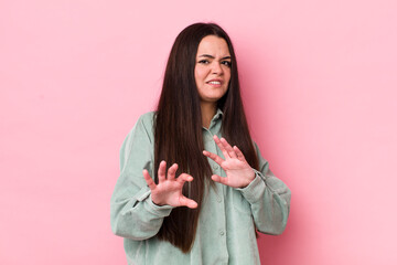 young adult woman feeling disgusted and nauseous, backing away from something nasty, smelly or...