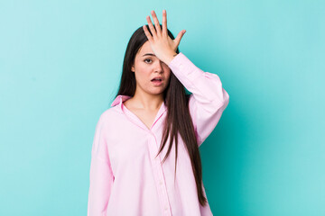 young adult woman raising palm to forehead thinking oops, after making a stupid mistake or...