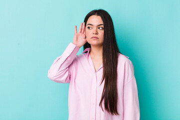 young adult woman looking serious and curious, listening, trying to hear a secret conversation or...