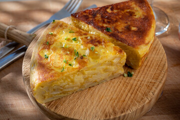Spanish vegetarian food, portion of homemade potato omelette tortilla de patatas with onion served...