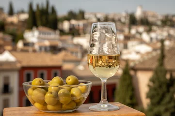 Fotobehang Tasting of Spanish sweet and dry fortified Vino de Jerez sherry wine and green olives with view on roofs and houses of old andalusian town © barmalini