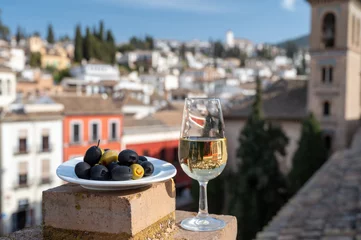 Fotobehang Tasting of Spanish sweet and dry fortified Vino de Jerez sherry wine and olives with view on roofs and houses of old andalusian town © barmalini