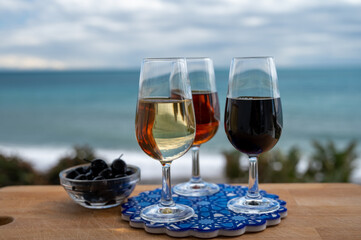 Tasting of Spanish sweet and dry fortified Vino de Jerez sherry wine and green olives with view on blue sea near El Puerto de Santa Maria, Andalusia, Spain