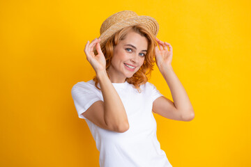 Fashion portrait pretty woman in summer straw hat over yellow background.