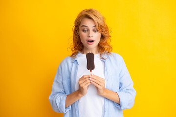 Photo of young woman eats delicious ice cream, enjoys frozen dessert, dressed in casual clothes,...