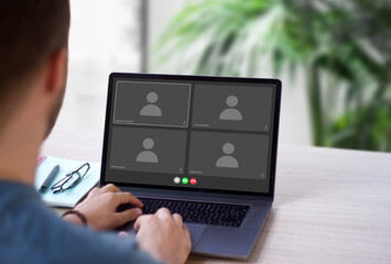 Video call screen interface on computer for online webinar. Young man using laptop with conference chat application to connect with his team.