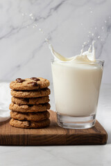 Cookies with chocolate chip. A glass of milk on the side. Splash photography.